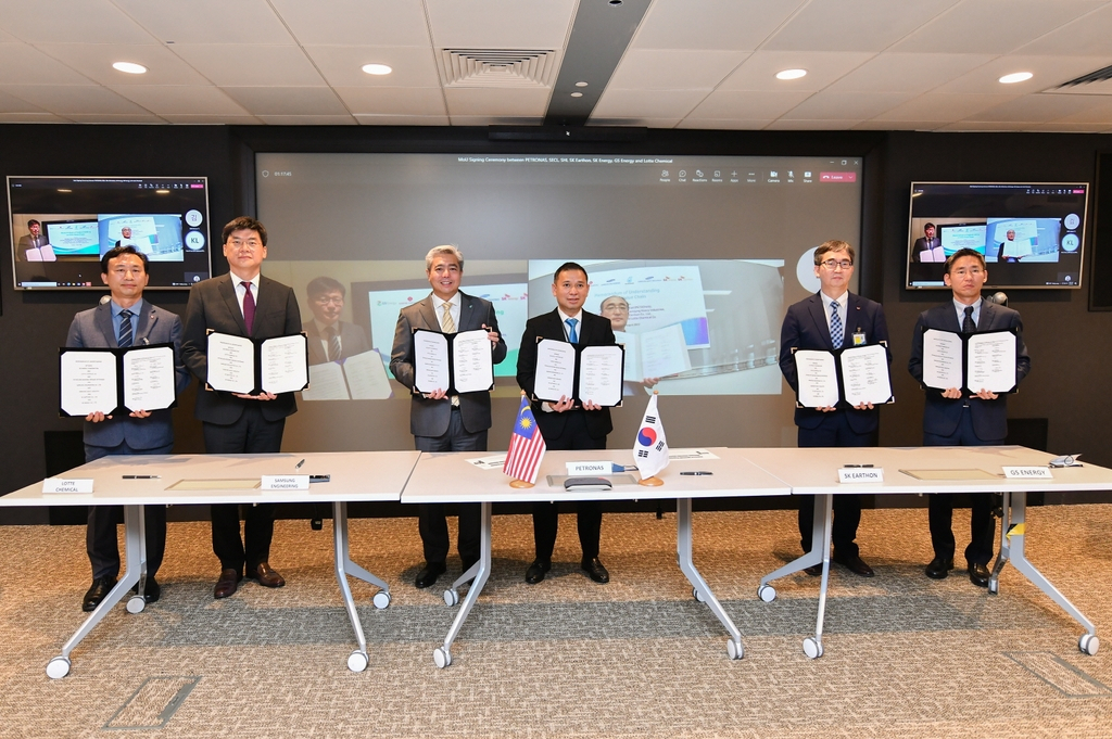 Officials of Lotte Chemical, Samsung Engineering, Petronas, SK Earthon and GS Energy pose for a photo after signing a memorandum of understanding for a project to capture, transport and store carbon dioxide in a virtual meeting in Kuala Lumpur, Malaysia, on Tuesday, in this photo provided by SK. (SK)