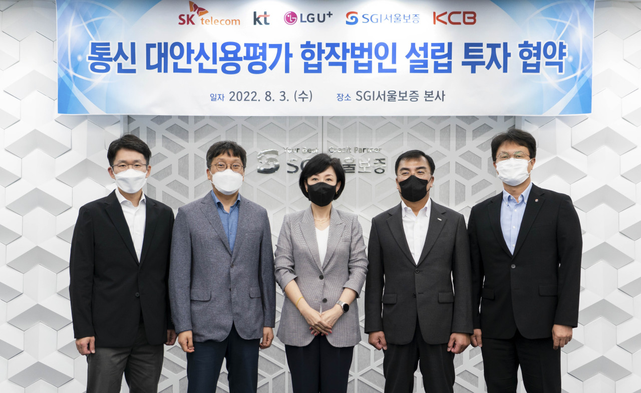 Officials of KT, SK Telecom, LG Uplus, Seoul Guarantee Insurance and Korea Credit Bureau pose for a photo at a signing ceremony held in SGI Building on Wednesday. (SK Telecom)