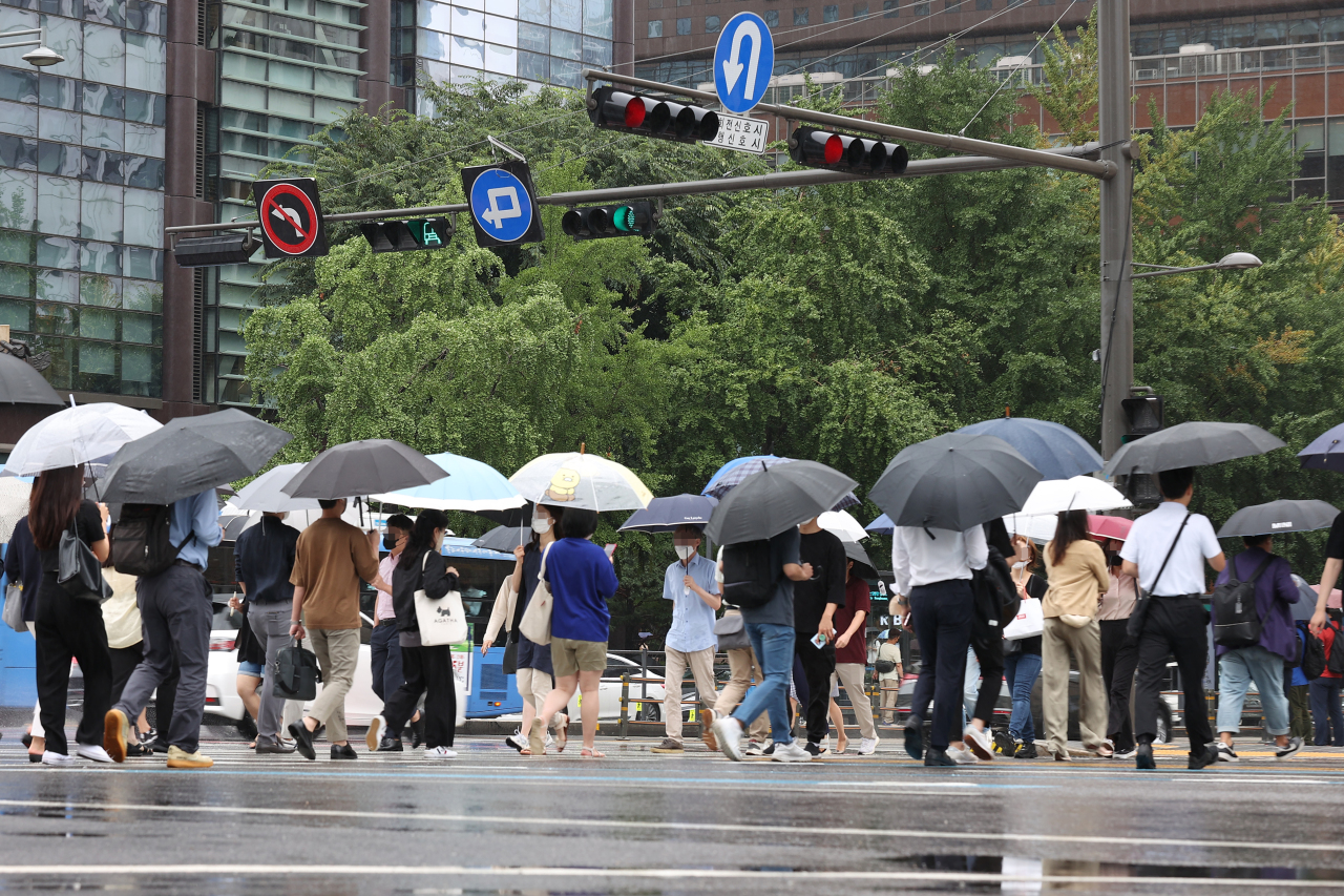 South Korean office workers communte to work on a rainy day in Central Seoul. (Yonhap)