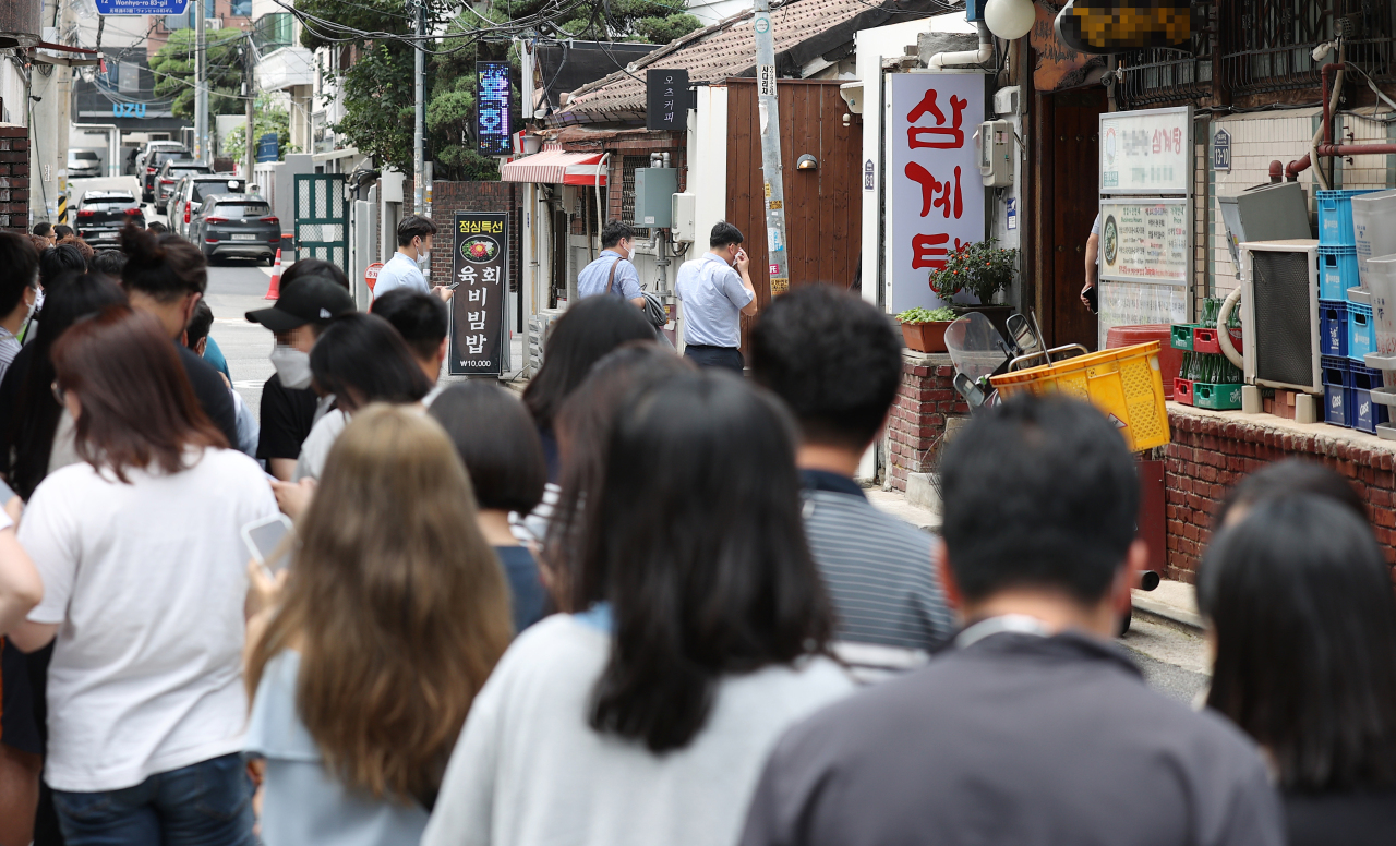 People stand in line at a samgyetang restaurant in Seoul, on jungbok, on July 26. (Yonhap)