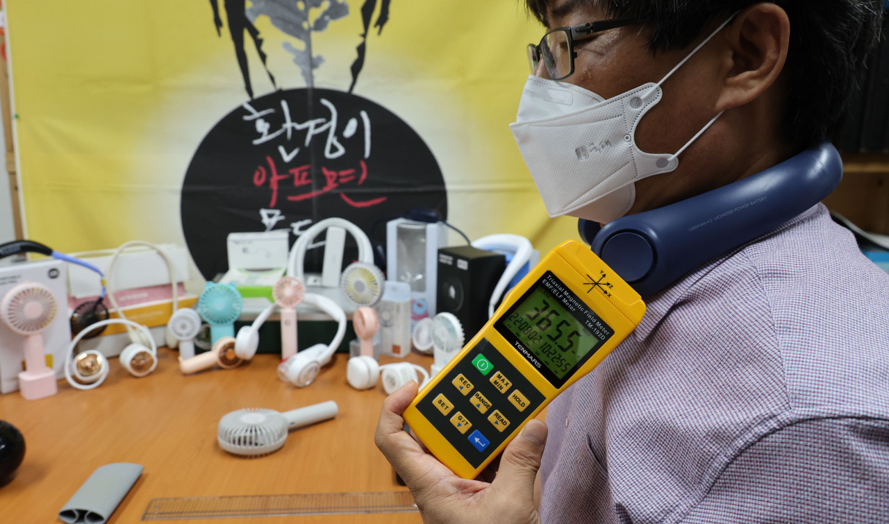 Choi Ye-yong, Director of Asian Citizen’s Center for Environment and Health, is measuring the electromagnetic field level of a neck fan on Aug. 2. (Yonhap)