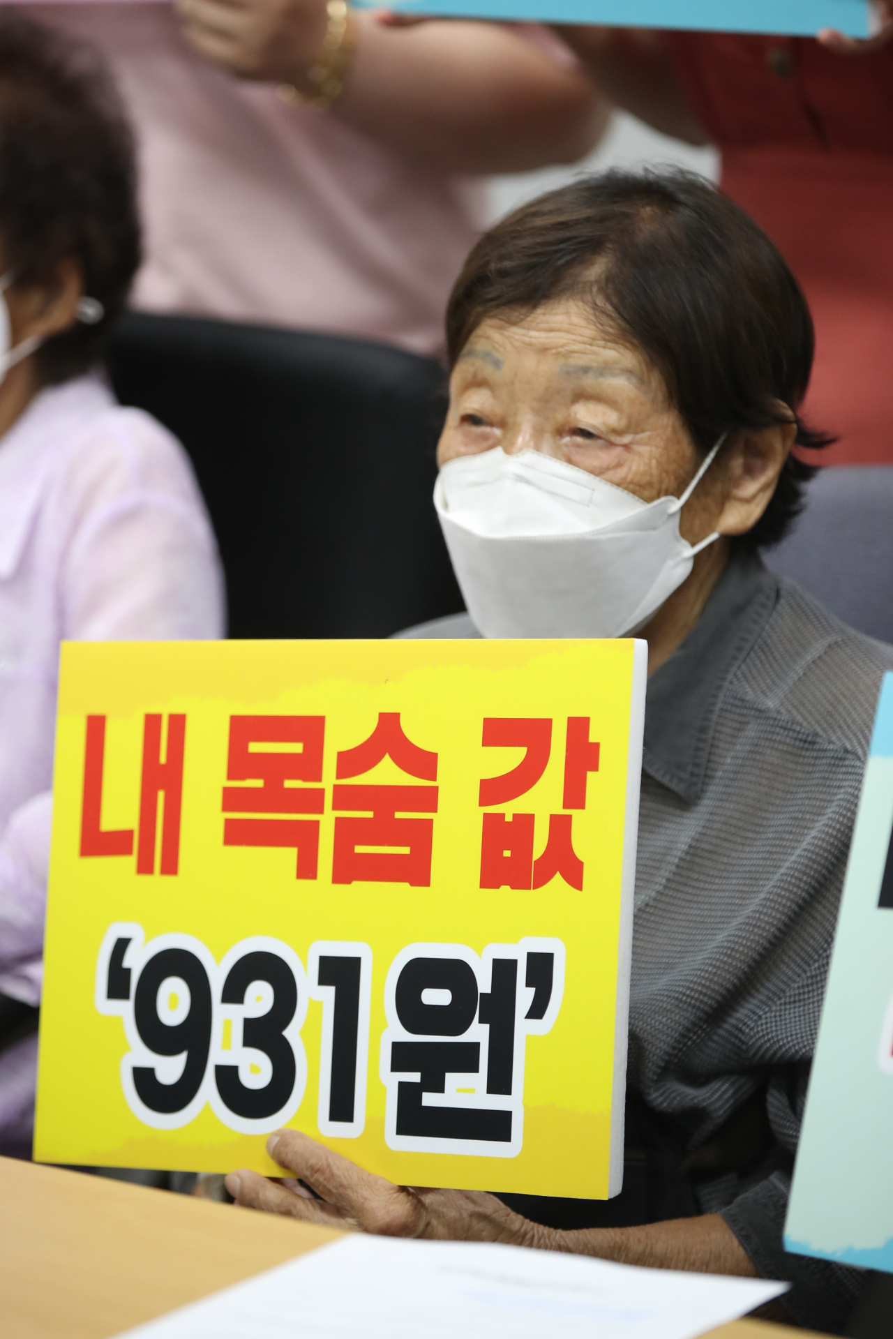 Chung Sin-young, a victim of forced labor under Japanese imperialism, holds a signboard that reads “The price of my life, 931 won” during a press conference held at Gwangju, Gyeonggi Province, Thursday. (Yonhap)