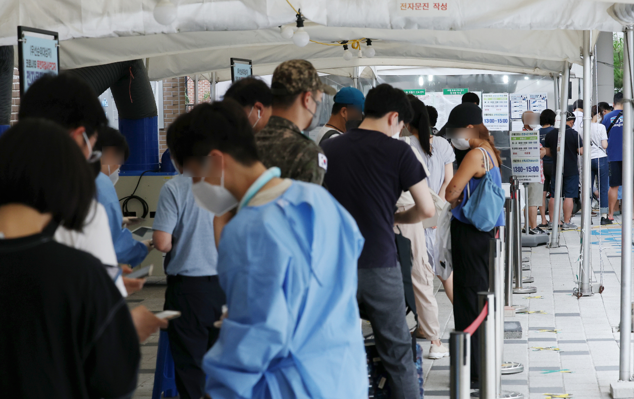 People line up to be tested for COVID-19 at a screening center in Seoul's western ward of Mapo on Friday. (Yonhap)