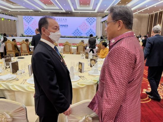 South Korean Foreign Minister Park Jin (right) speaks with North Korean Ambassador to Indonesia An Kwang-il during a welcome dinner held as part of the ASEAN Regional Forum in Phnom Penh on Thursday. (Yonhap)