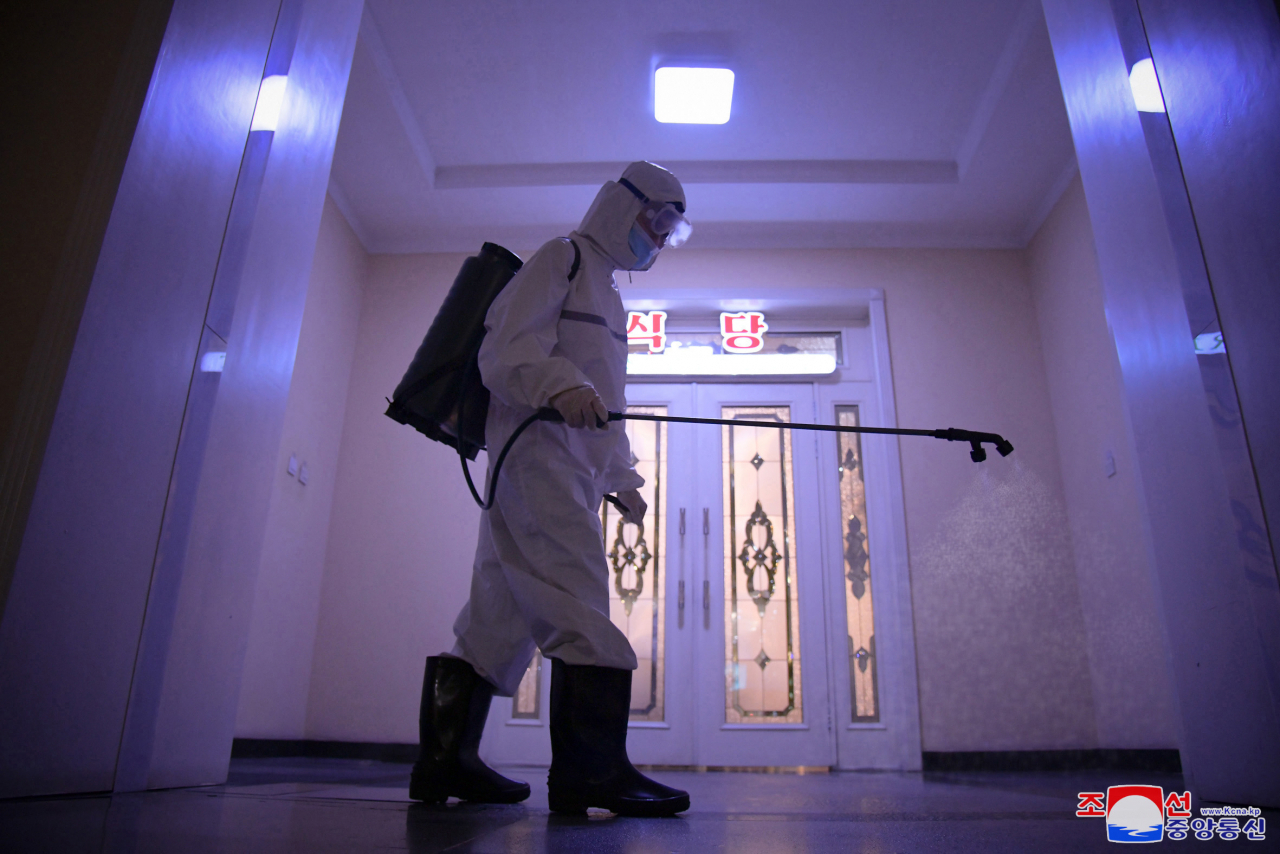 This photo, released by the North's Korean Central News Agency (KCNA) on July 1, 2022, shows an employee disinfecting Haebangsan Hotel in Pyongyang. (KCNA)