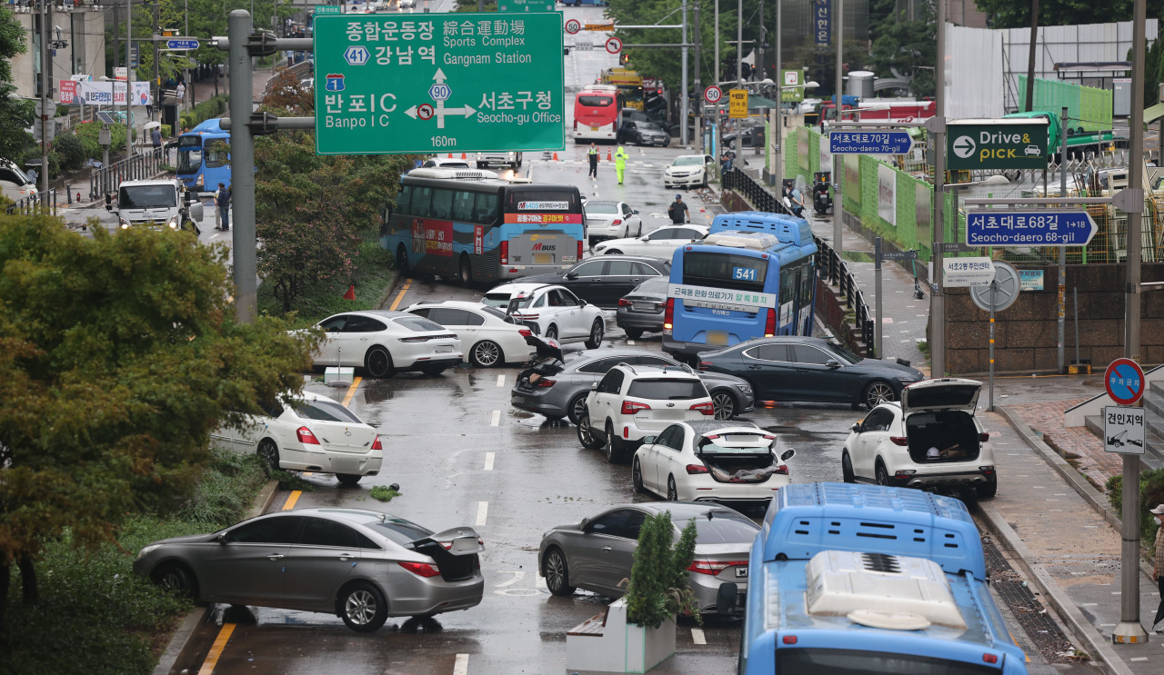 On Tuesday morning, vehicles that were submerged by heavy rain the previous day in the Seocho-daero area in front of Jinheung Apartment in Seocho-gu, Seoul, reemerge after evaporation. (Yonhap)
