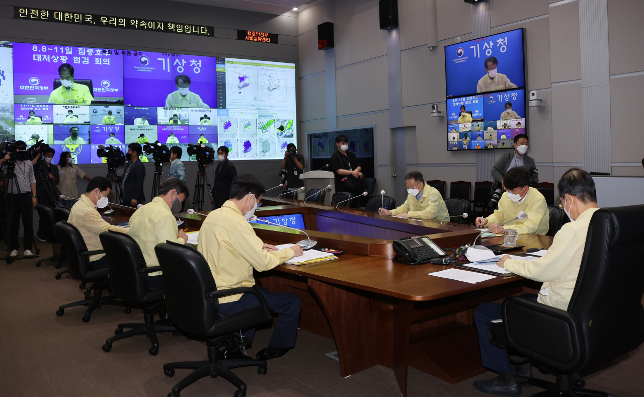 Prime Minister Han Duck-soo (C, head of table) presides over an emergency meeting at the government complex in Seoul on Thursday, to check countermeasures against record torrential rain in the country. (Yonhap)