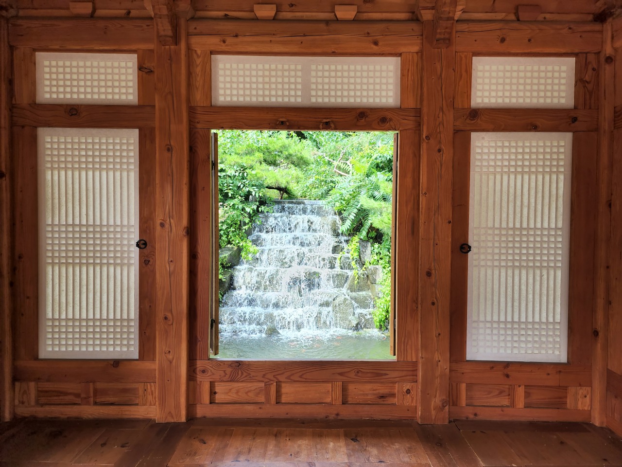 A view of an artificial waterfall from the small pavilion (Hwang Dong-hee/The Korea Herald)