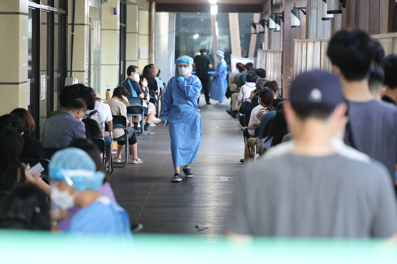 People wait in line for tests at a COVID-19 testing center in southeastern Seoul on Aug. 12, 2022. (Yonhap)