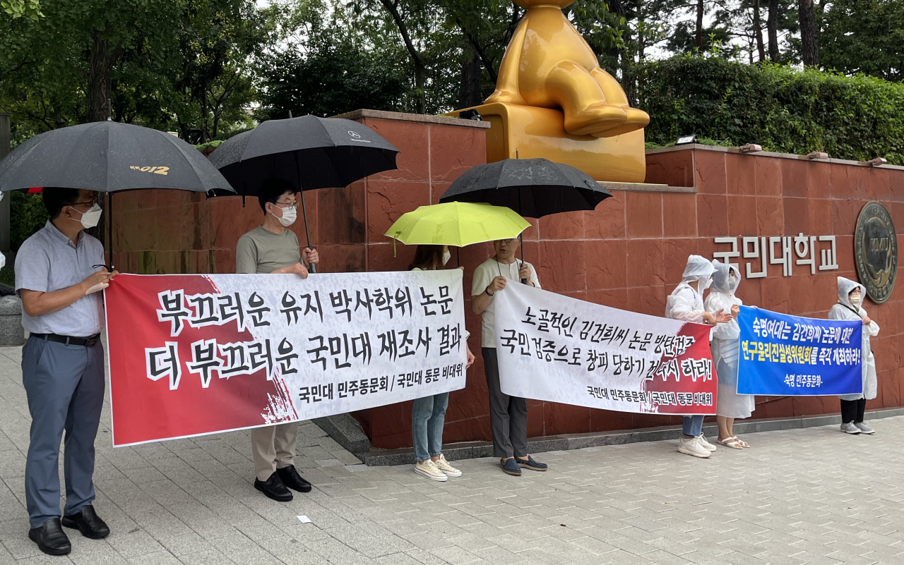 Alumni of Kookmin University hold a protest, calling for the university to reinvestigate papers written by the first lady Kim Keon-hee, in front of the university on Aug. 8. (Yonhap)