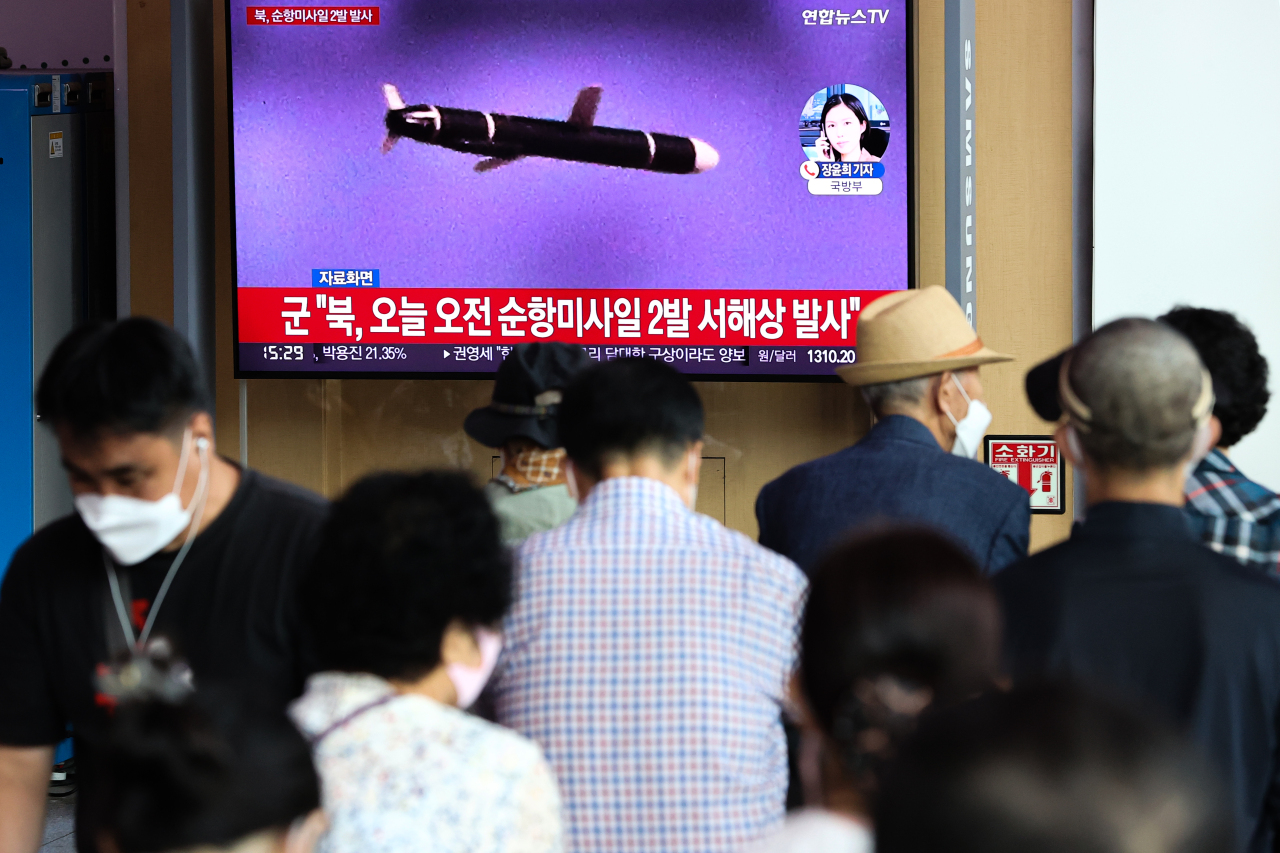 Passersby watch a TV report of North Korea’s missile launch at Seoul Station on Wednesay.(Yonhap)