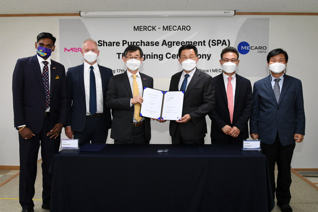 Representatives of Merck and Mecaro, including Managing Director of Merck Korea Kim Woo-kyu (third from left), pose for a photo during a signing ceremony held Wednesday. (Merck Korea)
