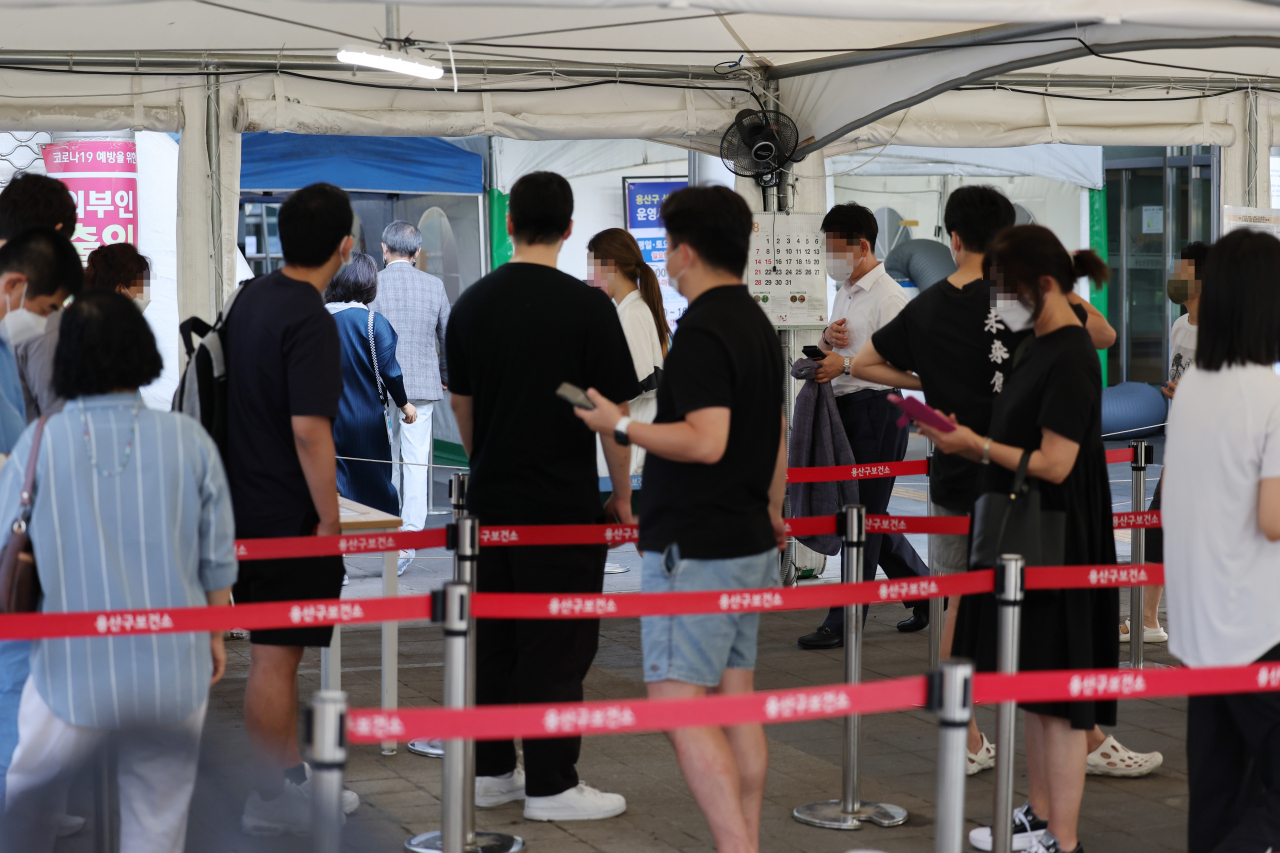 People line up to undergo COVID-19 virus tests at a makeshift testing station in Seoul on Thursday. (Yonhap)