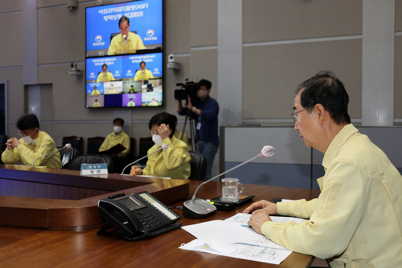 Prime Minister Han Duck-soo (L) presides over a meeting on African swine fever (ASF) at the government complex in Seoul on Friday, as an ASF case was confirmed at a pig farm in Yanggu, 175 kilometers northeast of Seoul. (Yonhap)