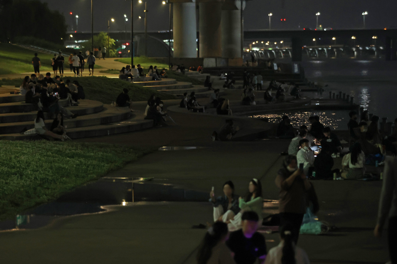 Crowds are seen eating and drinking at Han River park after 10 p.m. on July 4. (Yonhap)