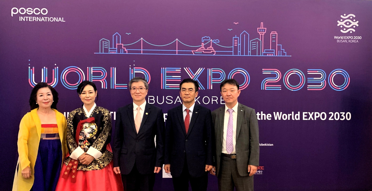 Korean Ambassador to Uzbekistan Kim Hee-sang (third from left) and Posco International Textile’s President of Corporation at Central Asia Region Cho Seung-hyun (fourth from left) pose for a photo in front of Busan Expo poster in Tashkent, Uzbekistan, Sunday. (Posco International)