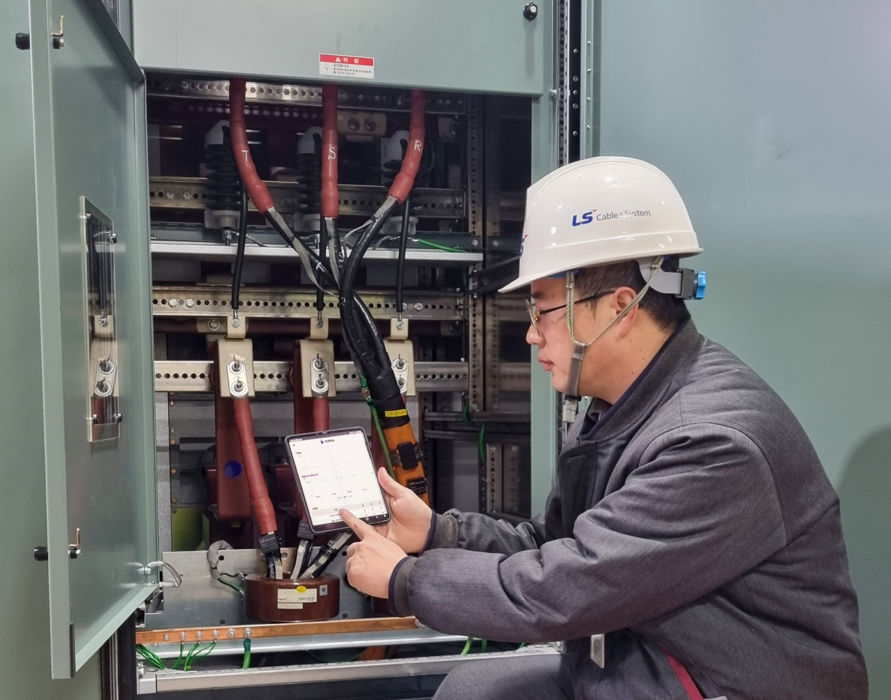 An LS Cable & System worker monitors the status of power distribution cables with an i-check system installed on a mobile device. (LS Cable & System)