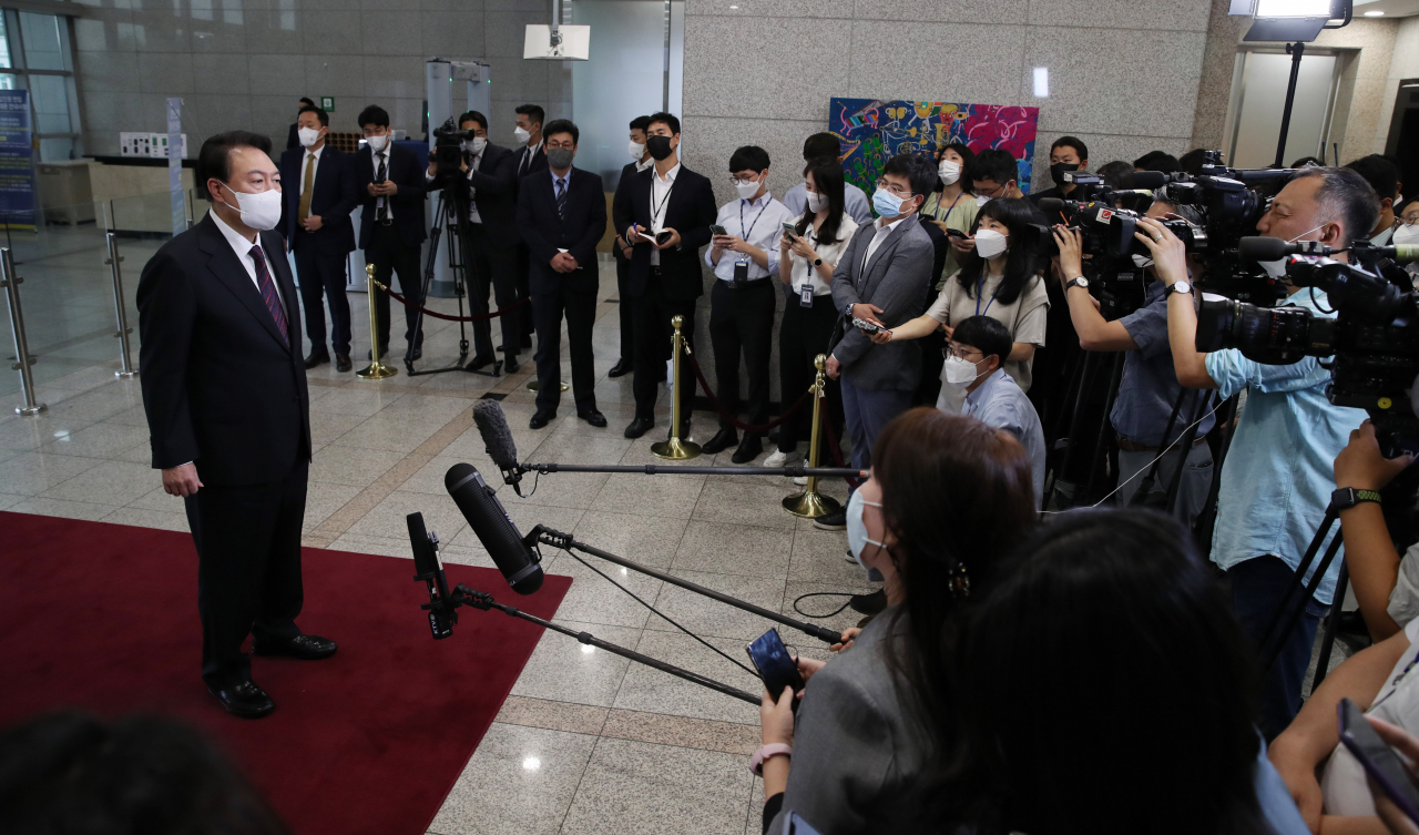 President Yoon Suk-yeol takes reporters' questions as he arrives at the presidential office in Seoul on Monday. (Yonhap)