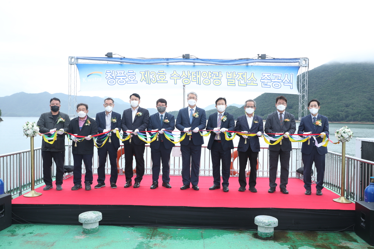 K-water CEO Park Jae-hyun (fifth from right) participates in the ribbon cutting ceremony for Chungju Dam's third floating photovoltaic power plant on Wednesday at Chungju Lake, North Chungcheong Province. (K-water)