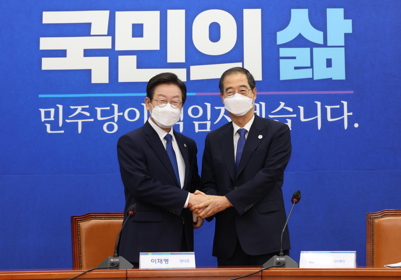 Prime Minister Han Duck-soo (R) and Lee Jae-myung, new leader of the Democratic Party, pose for a photo before holding a meeting on Thursday. (Yonhap)