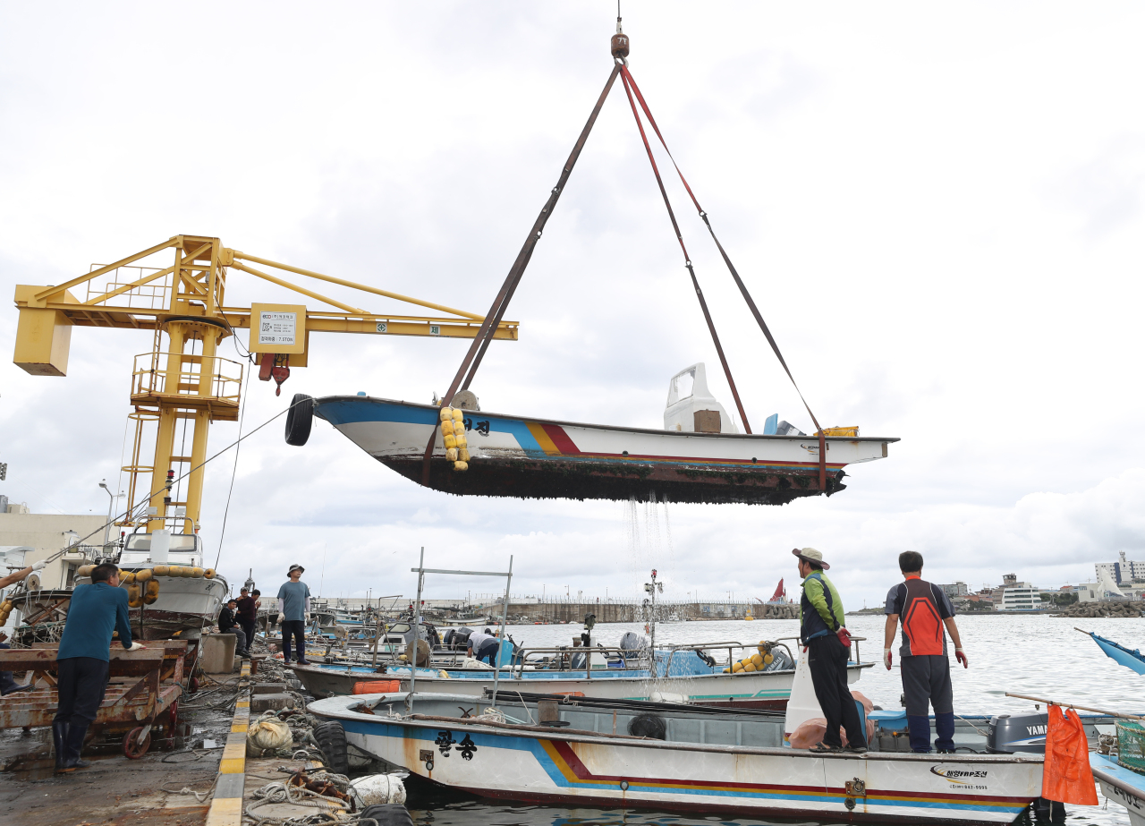 Fishing boat is moved onto land at Jeongja Port in Ulsan on Friday. (Yonhap)