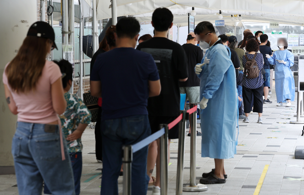 People wait in line for COVID-19 tests at a local testing station in Mapo-gu, Seoul, on August 19. (Yonhap)