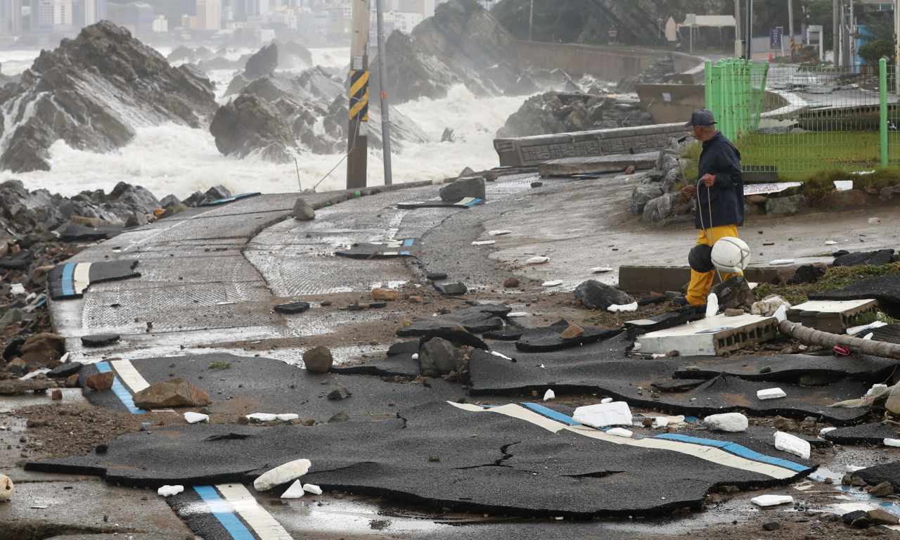 A road is damaged as waves hit a shore in Ulsan, Tuesday. (Yonhap)