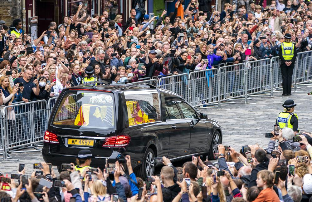 The hearse carrying the coffin of Queen Elizabeth II, draped with the Royal Standard of Scotland, passes the City Chambers on the Royal Mile, Edinburgh, Sunday on the journey from Balmoral to the Palace of Holyroodhouse in Edinburgh, where it will lie in rest for a day. (Jane Barlow)