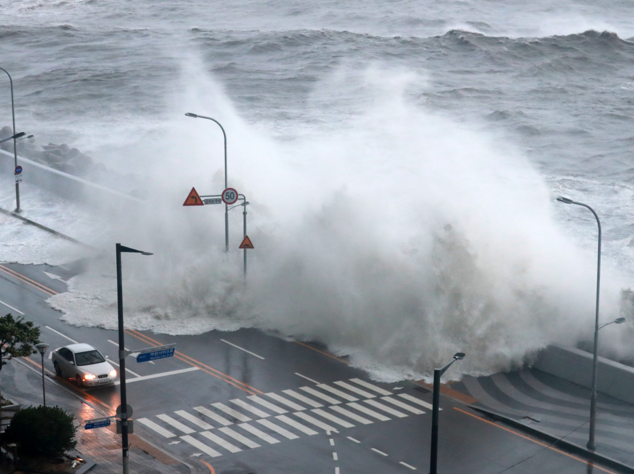 In this file photo, a wave of water engulfs a seaside road in Busan last Tuesday as Typhoon Hinnamnor makes landfall in South Korea. (Yonhap)