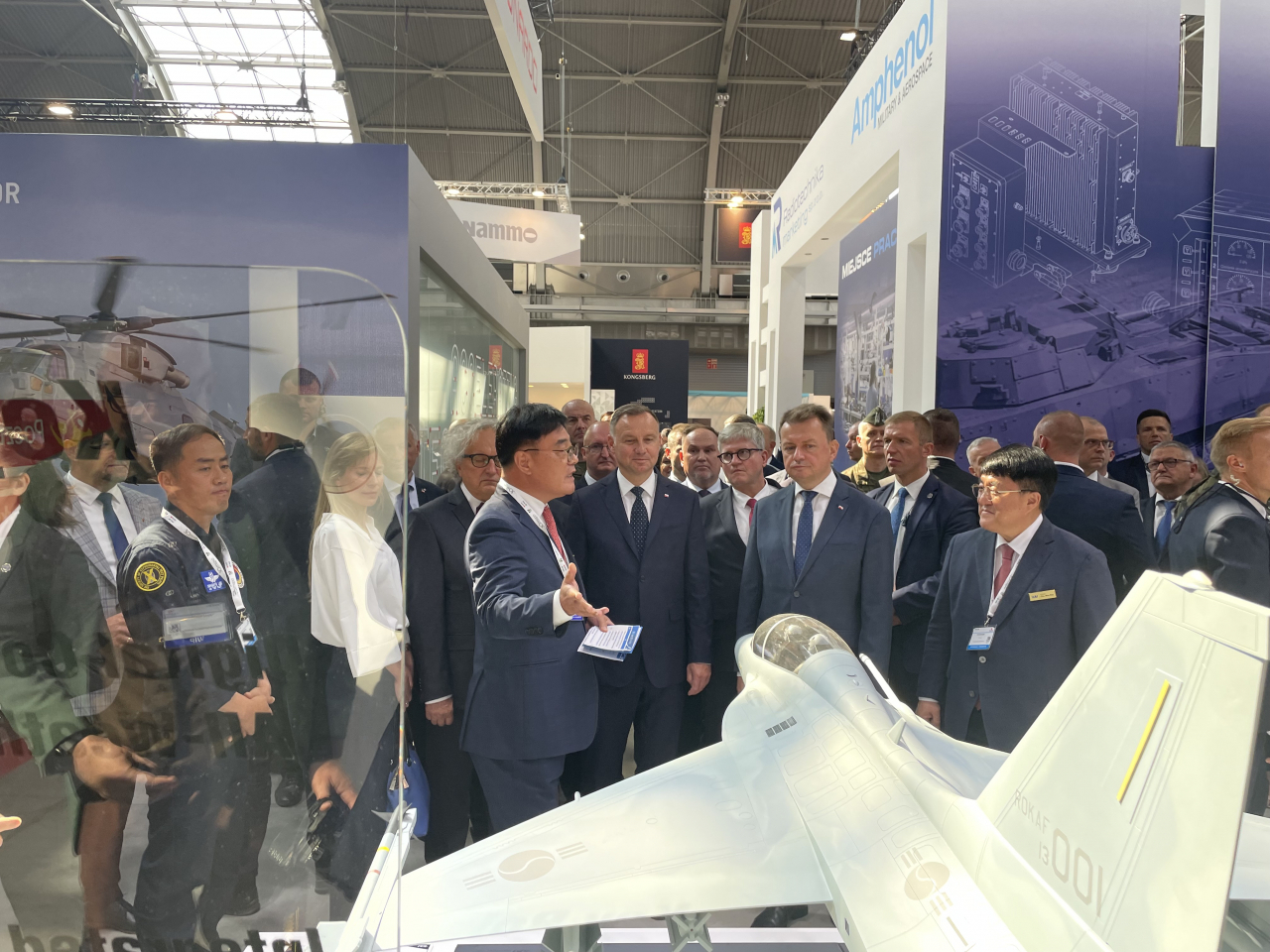 Polish President Andrzej Duda (2nd from right) listens to explanations from KAI executive Lee Bong-geun (4th from right) of the South Korean aircraft manufacturer's FA-50 fighter jet at the 30th International Defence Industry Exhibition in Poland. (KAI-Yonhap)