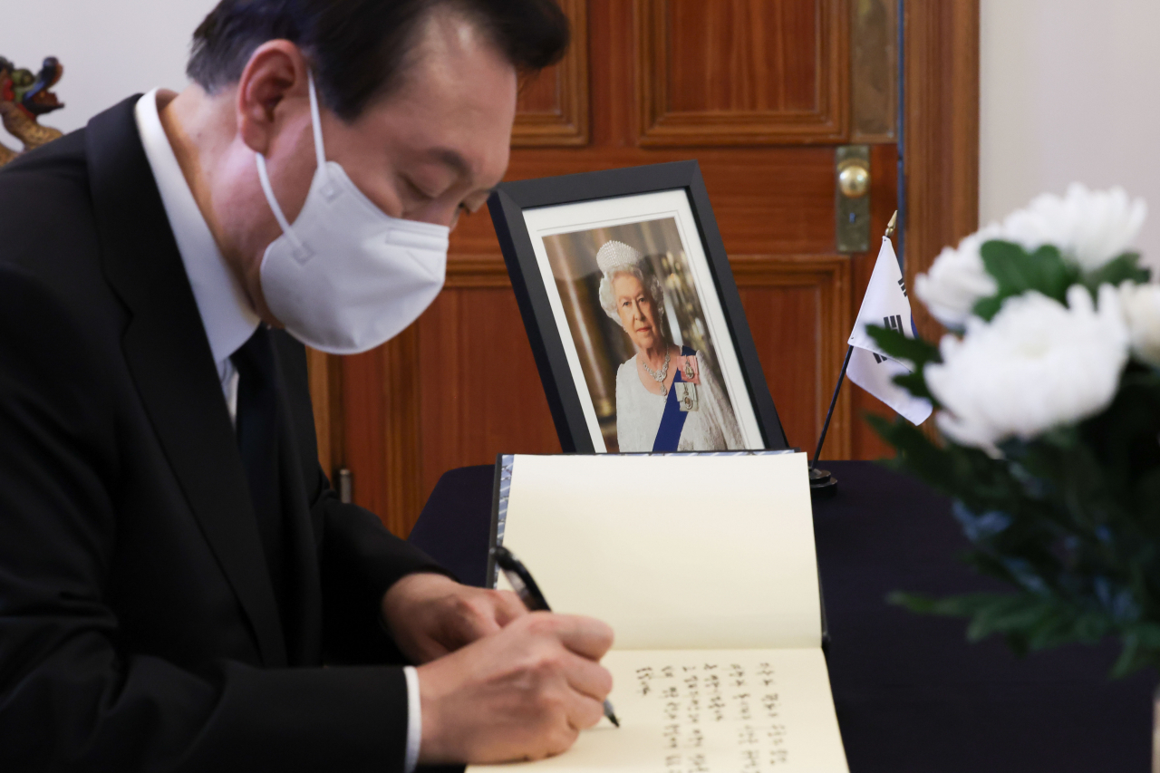 President Yoon Suk-yeol signs a guest book after paying tribute to the late Queen Elizabeth II at a memorial hall set up at the British Embassy in Seoul last Friday, in this file photo provided by his office. (Yonhap)