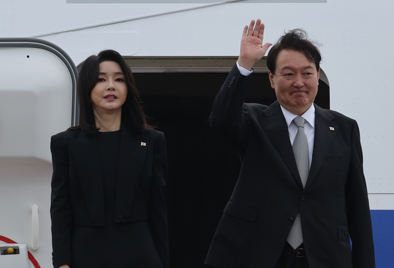 President Yoon Suk-yeol and first lady Kim Keon-hee pose for photos before leaving for London on Sunday, for a three-nation trip that will take them to the United States and Canada. (Yonhap)