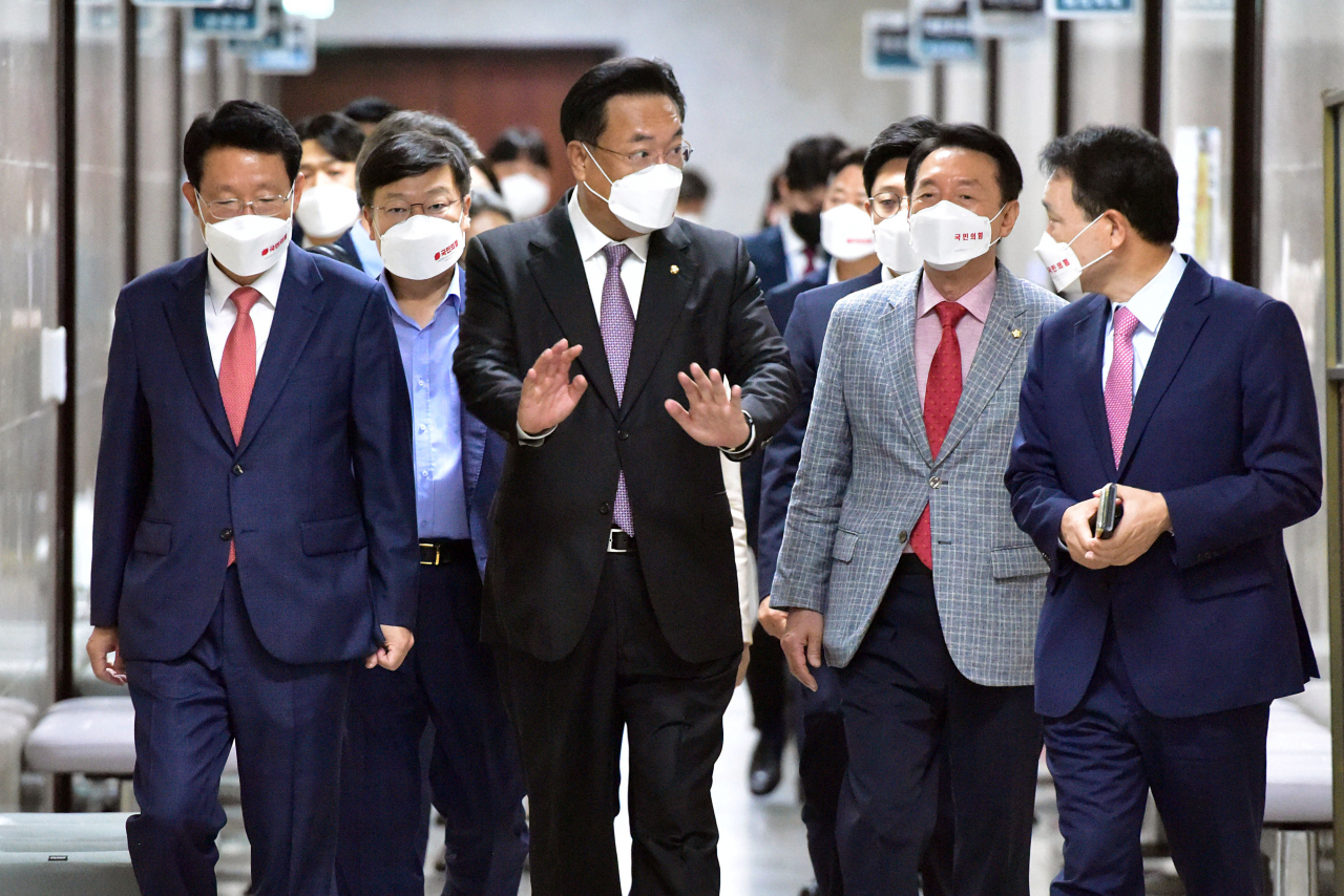 Ruling People Power Party Emergency Committee Chairman Chung Jin-suk (C) talks to party members on his way to attend a party meeting at the National Assembly on Monday. (Yonhap)