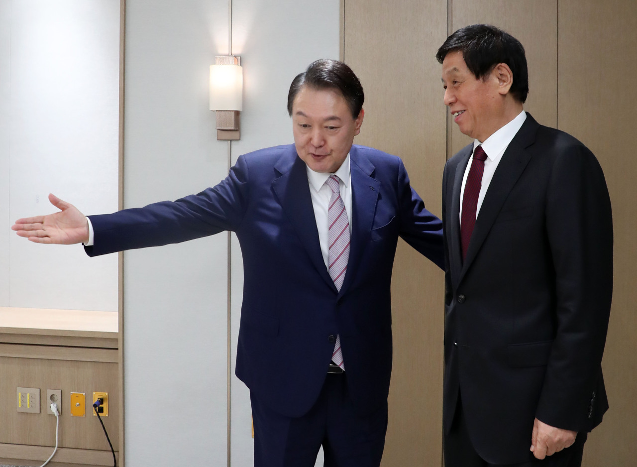 South Korean President Yoon Suk-yeol welcomes Li Zhanshu, Beijing’s third-highest-ranking official and chief of the Standing Committee of the National People’s Congress, who is paying a courtesy call, at the presidential office in Seoul on Friday. (Yonhap)