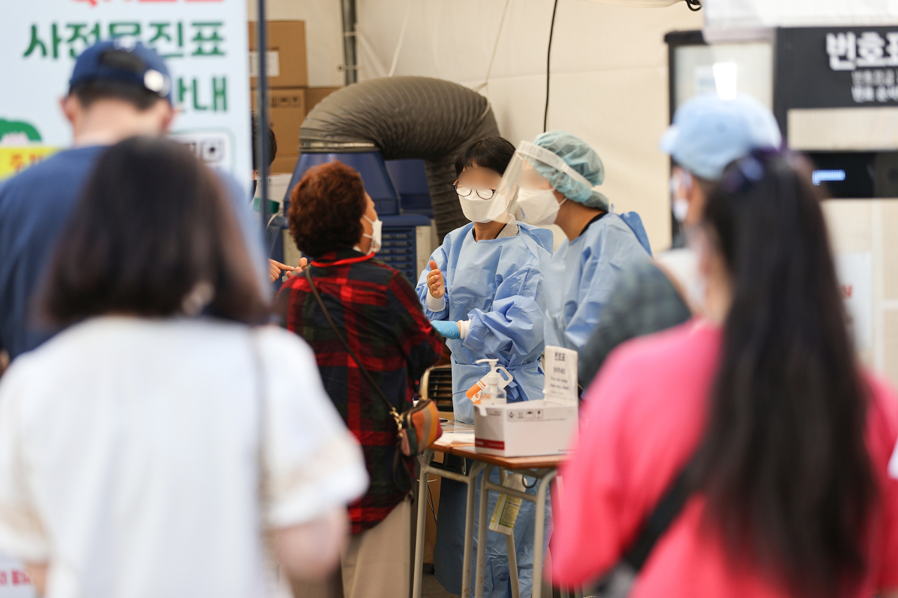 People wait in line at a COVID-19 testing center in Seodaemun-gu, Seoul. (Yonhap)
