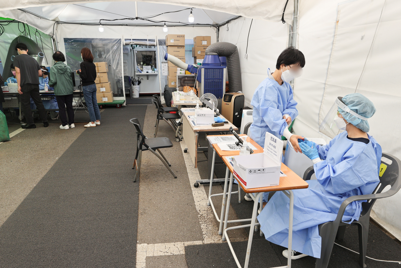 Medical workers get ready for work at a COVID-19 testing station in a community health center in Seoul's western district of Seodaemun on Wednesday. (Yonhap)