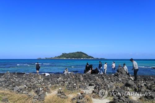 Tourists walk along the coast of Jeju Island on Sept. 22, 2022. (Yonhap)