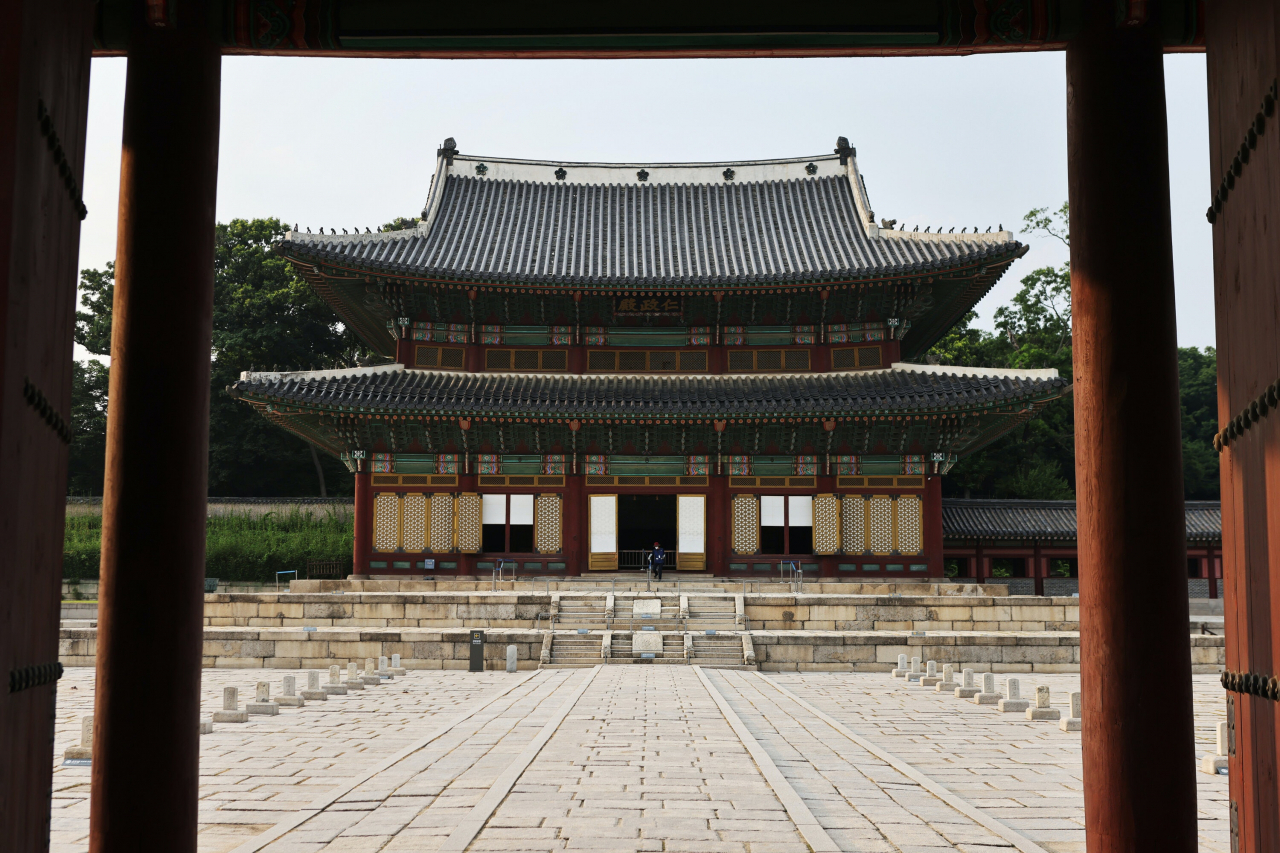 Injeongjeon Hall, the official daily office of the Joseon kings, is seen through the gate with the granite stone covered plaza at Changdeokgung in Seoul. Photo © Hyungwon Kang