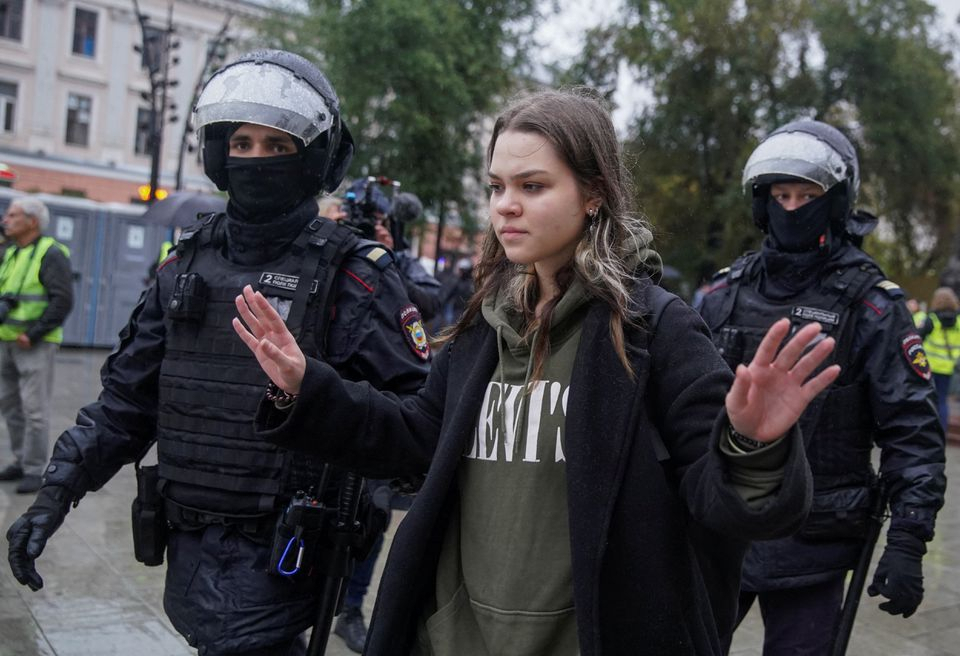 Russian law enforcement officers lead away a person during a rally, after opposition activists called for street protests against the mobilization of reservists ordered by President Vladimir Putin, in Moscow, Russia Sunday. (Reuters-Yonhap)