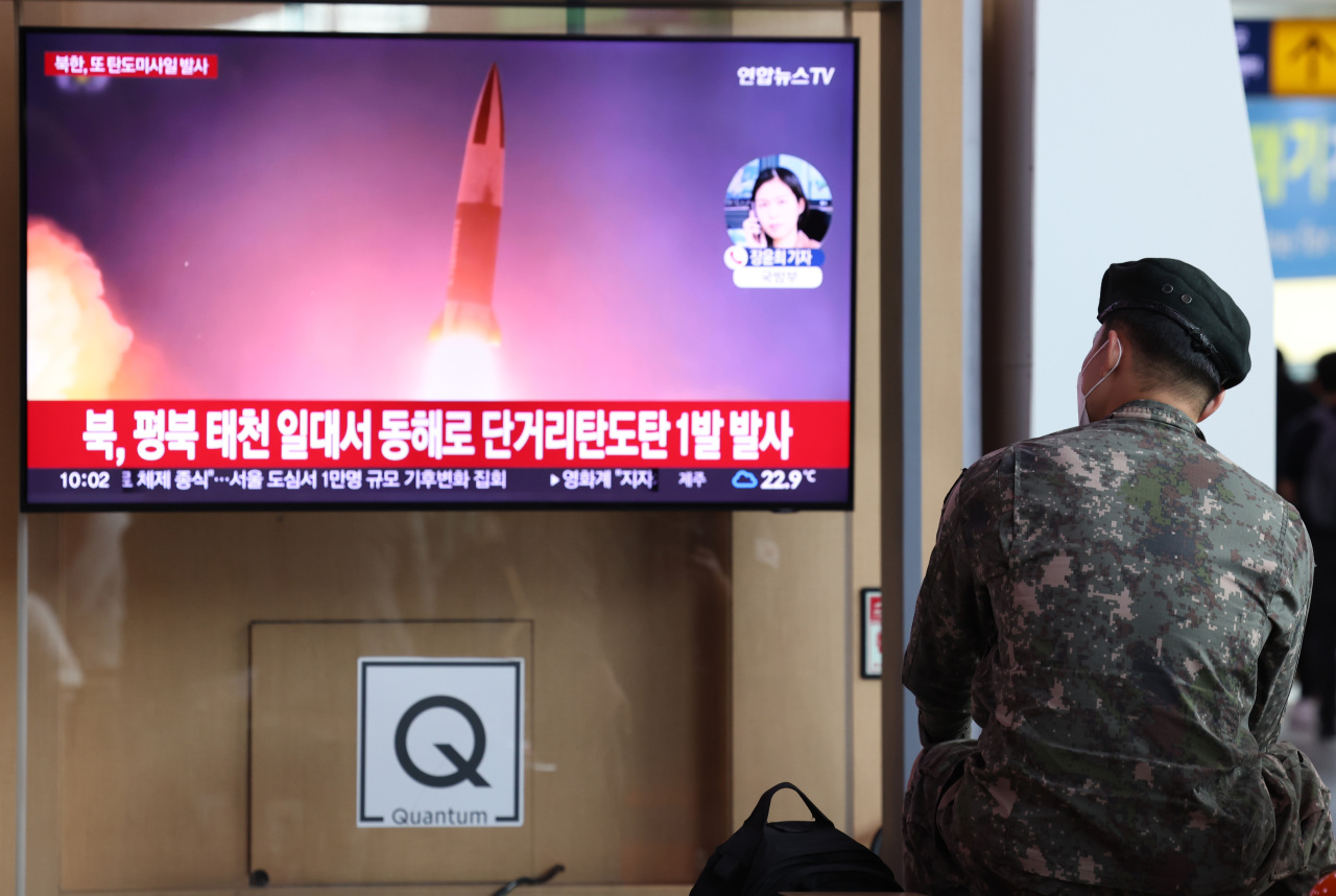 A man watches a television news report on North Korea's firing of suspected artillery shots, at Seoul Station in the capital city on Sunday. (Yonhap)