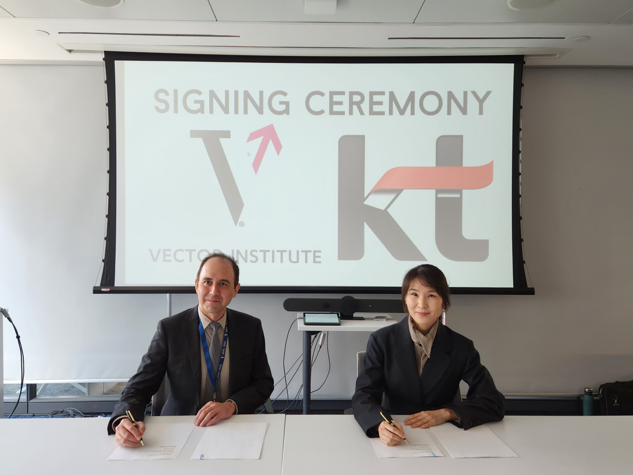 Kim Chae-hee (right), head of the strategy and planning division at KT, and Alan Veerman, chief operations officer of the Vector Institute, sign a partnership agreement at the Vector Institute in Toronto on Thursday. (KT)