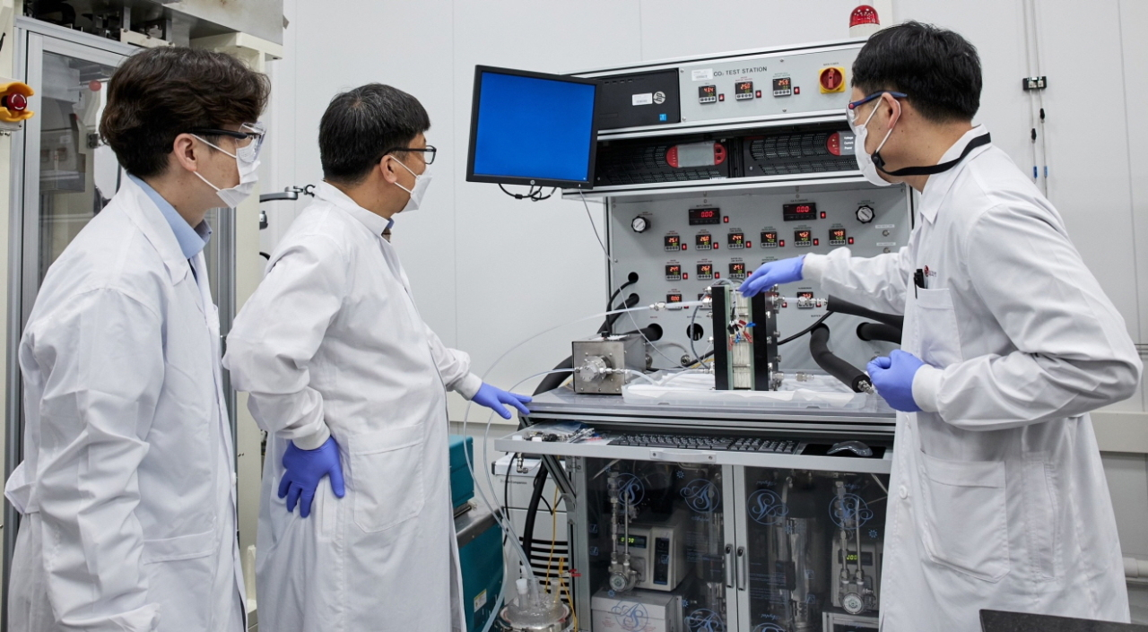 Researchers stand in front of a electrochemical reactor that converts carbon dioxide into carbon monoxide, jointly developed by LG Chem and the Korea Institute of Science and Technology. (LG Chem)