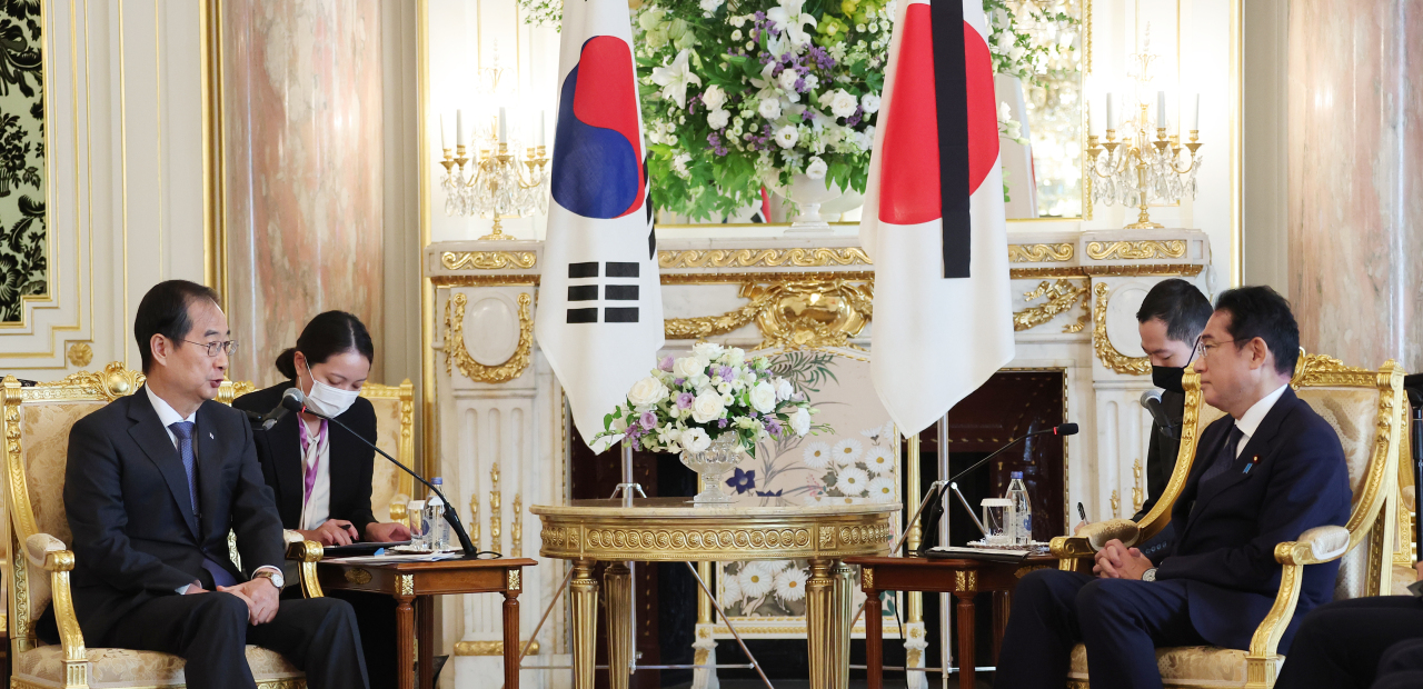 South Korean Prime Minister Han Duck-soo (left) speaks with Japanese Prime Minister Fumio Kishida in Tokyo on Wednesday morning at the state guest house Akasaka Palace. (Yonhap)