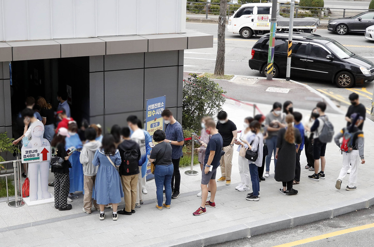 Foreign students wait in line to be tested of COVID-19 before being admitted to enter dormitories at a testing booth in Gwangju on Aug. 29. (Gwangju City Buk-gu) 