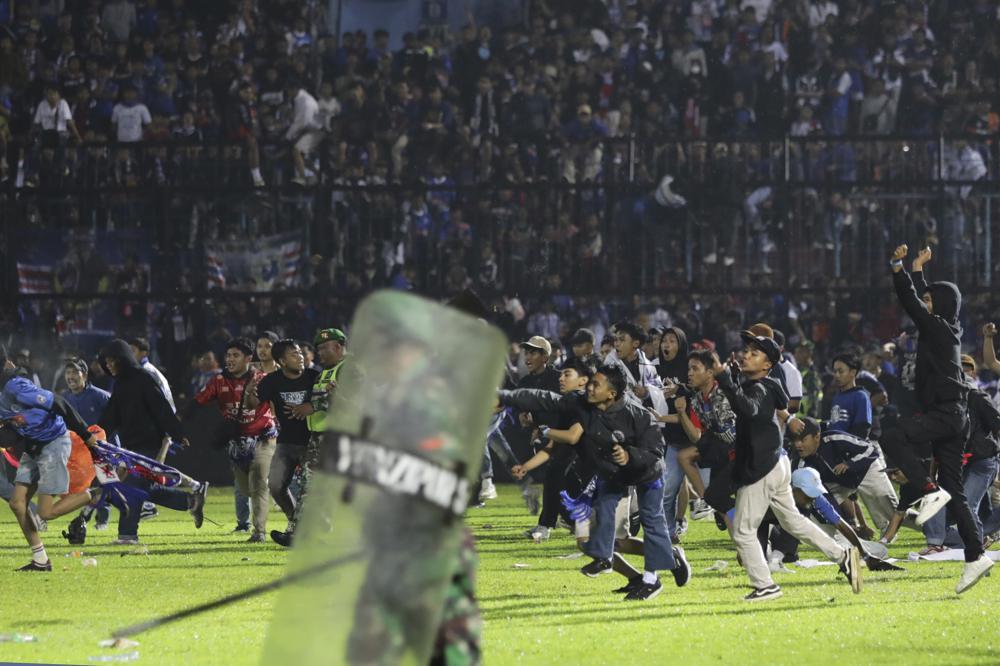 Soccer fans enter the pitch during a clash between supporters at Kanjuruhan Stadium in Malang, East Java, Indonesia, Saturday, Oct. 1, 2022. Clashes between supporters of two Indonesian soccer teams in East Java province killed over 100 fans and a number of police officers, mostly trampled to death, police said Sunday. (AP-Yonhap)