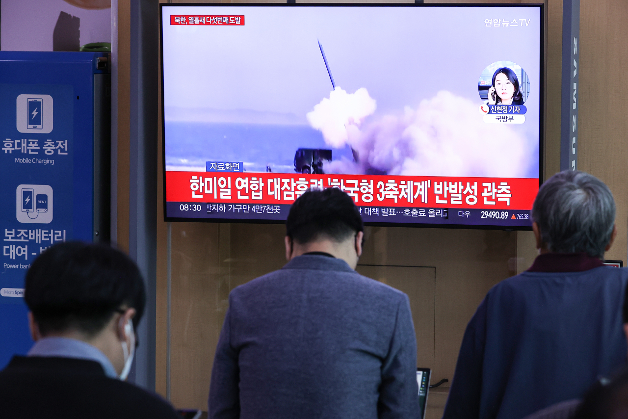 This photo, taken Tuesday shows citizens watching TV news at Seoul Station in central Seoul that reported North Korea fired an intermediate-range ballistic missile over Japan. (Yonhap)