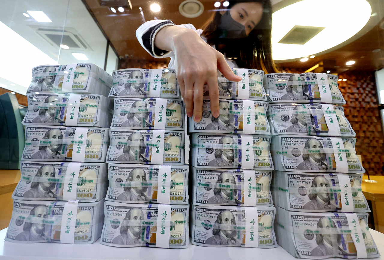 An employee counts US dollar notes at the Hana Bank headquarters in downtown Seoul, Thursday. (Yonhap)