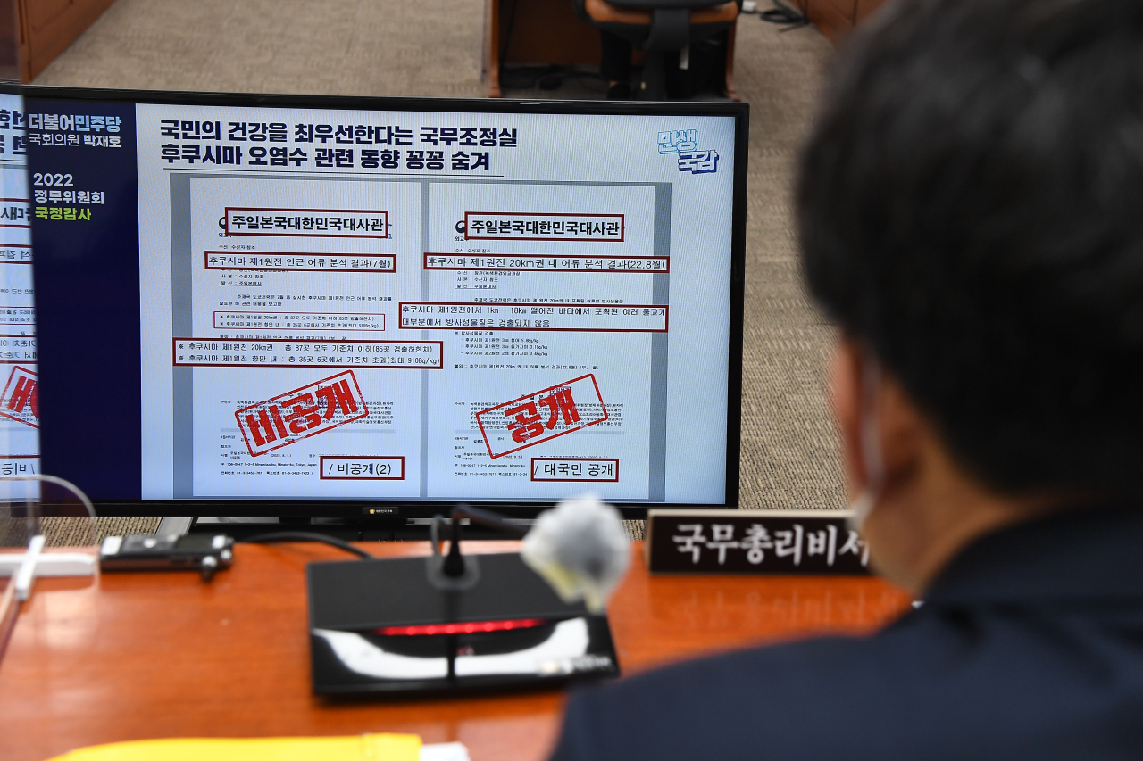 An official from the Office for Government Policy Coordination looks at reports on radioactive water from the Fukushima nuclear power plant during a National Assembly audit held Tuesday. (Joint Press Corps)