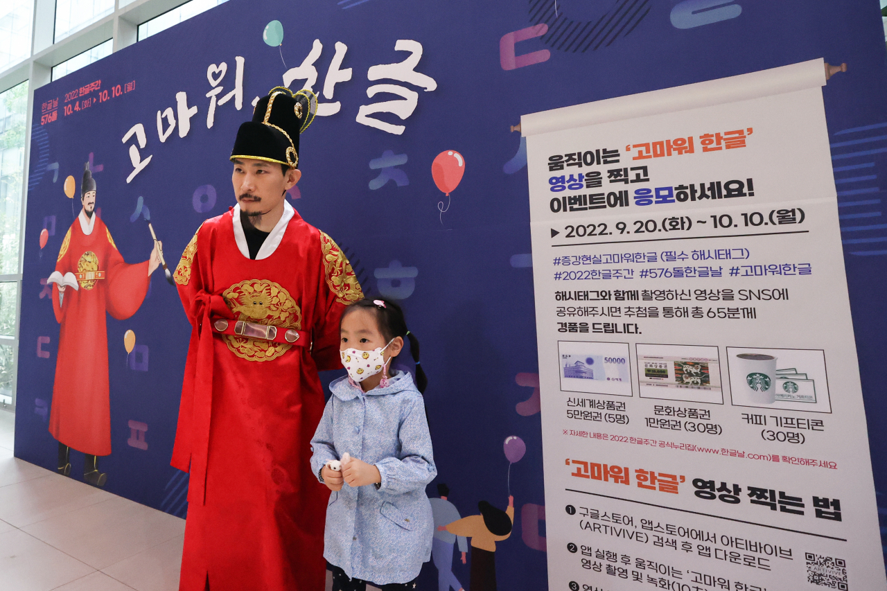 A child takes a photo with a museum worker dressed as King Sejong at the National Hangeul Museum in Yongsan, Seoul, Tuesday. (Yonhap)