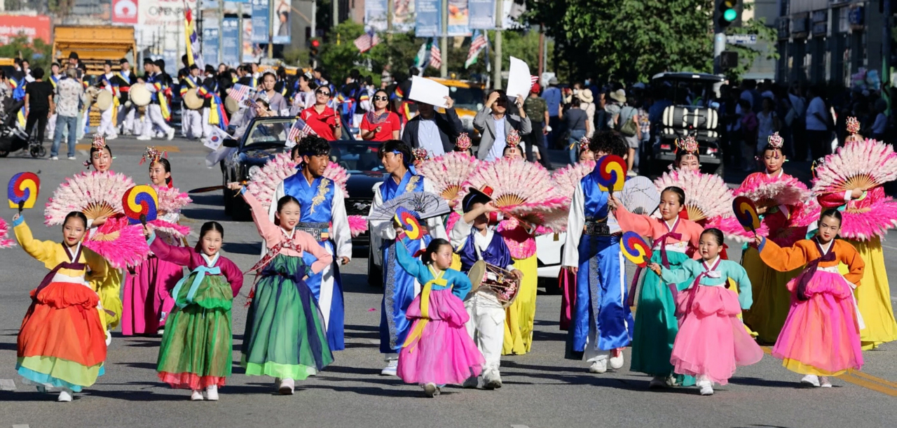 Young Korean American girls wearing colorful hanbok dance and walk while moving along the annual Korean Festival Parade in Los Angeles Koreatown on Sept. 24.Photo © Hyungwon Kang